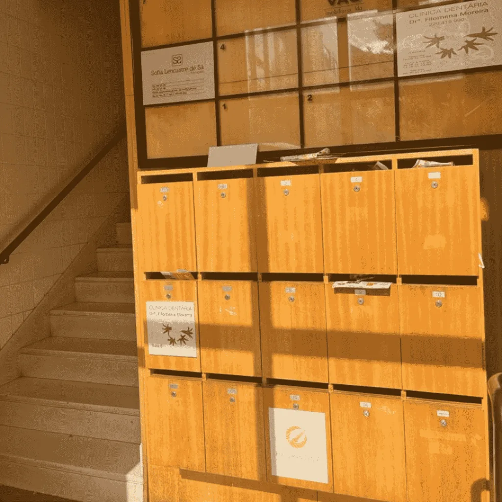 Átrio do edifício, com as escadas e os marcos de correio dos escritórios